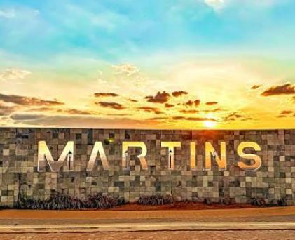 Letreiro de Martins ao pôr do sol, com o céu colorido ao fundo